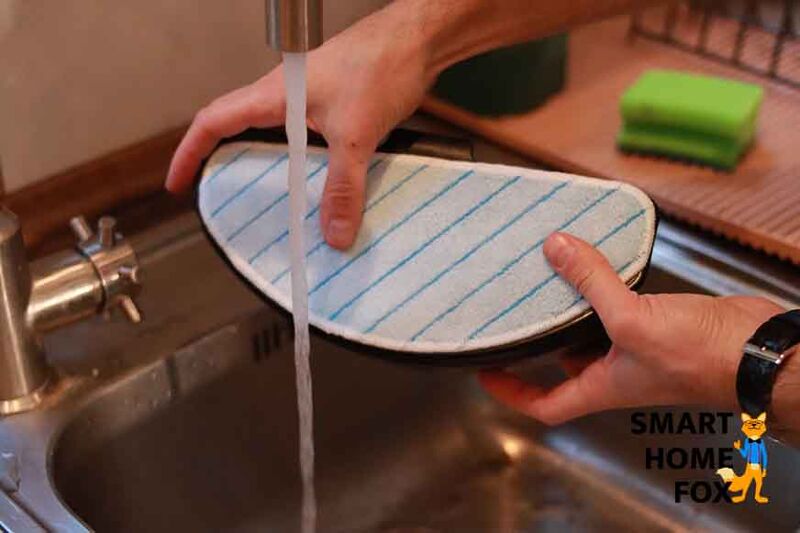 Das Wischtuch des Ecovacs Deebot T9 AIVI wird unter fließendem Wasser befeuchtet